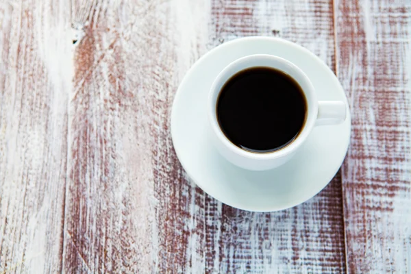 A xícara de café é isolada em um fundo de madeira branca — Fotografia de Stock