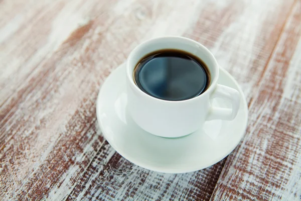 La tazza di caffè è isolata su uno sfondo di legno bianco — Foto Stock