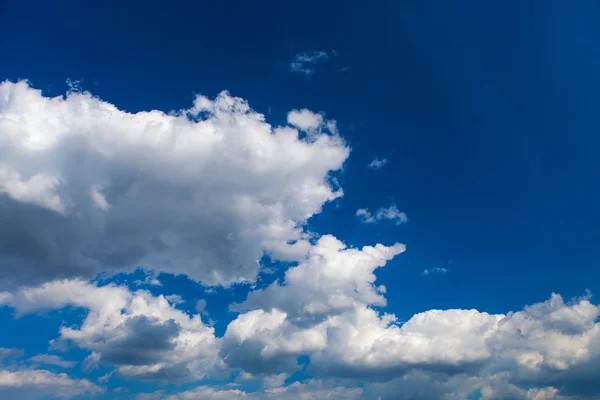 Blauwe lucht achtergrond met kleine witte wolken — Stockfoto