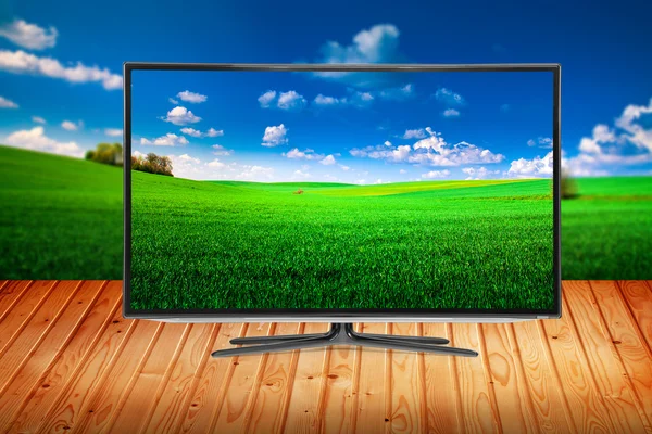 TV på ett träbord på en bakgrund natur — Stockfoto