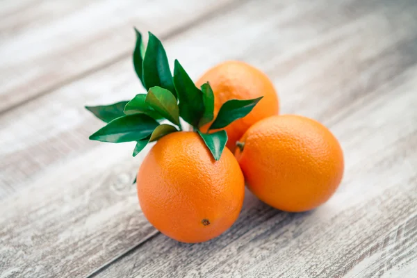 Reife Orangen mit grünen Blättern — Stockfoto