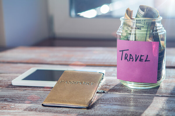 Objects for travel, passport, mobile phone and money on a wooden background