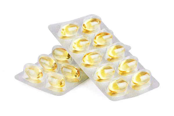 Pílulas amarelas em branco — Fotografia de Stock