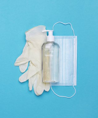 Yüz maskesi, el dezenfektanı şişesi ve lateks eldivenler. Coronavirus önleme tıbbi maske, el dezenfektanı jeli, el hijyen koronavirüsü koruması. Mavi bir arkaplanda.