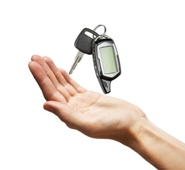 Araba anahtarı elinde, beyaz arka planda izole edilmiş.