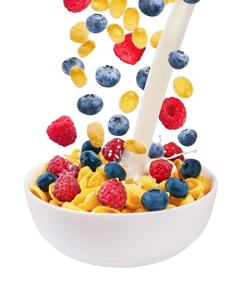 Falling corn flakes with fresh berries and pouring milk — Stock Photo, Image