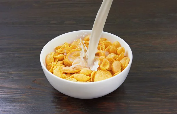 Gieten van melk in cornflakes — Stockfoto