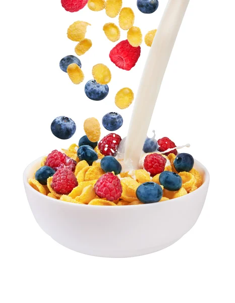 Falling corn flakes with fresh berries and pouring milk — Stock Photo, Image