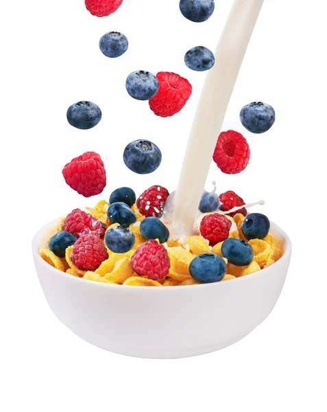 Falling fresh berries and pouring milk in corn flakes — Stock Photo, Image