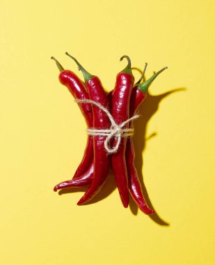 Sarı arka planda ipli kırmızı biberler