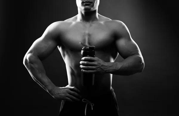 Mann Bodybuilder hält einen Shaker für Getränke — Stockfoto
