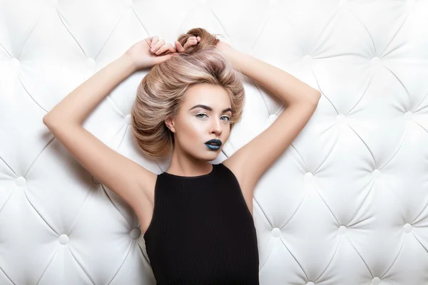 Studio portrait of a sexy blond in black dress — Stock Photo, Image