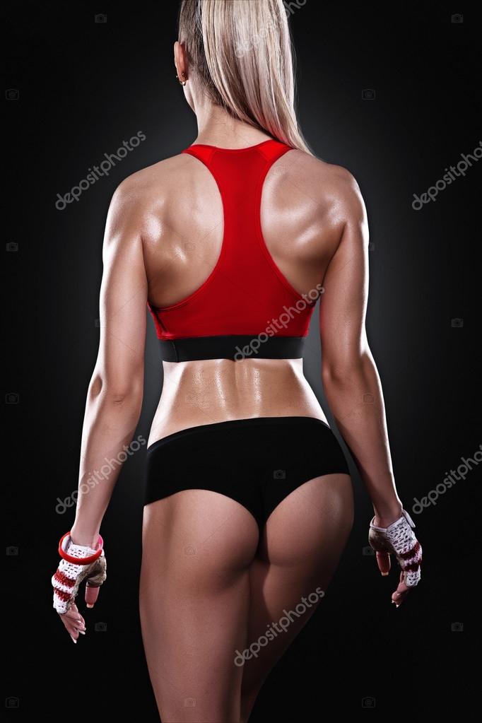 Athletic young woman showing muscles of the back Stock Photo by