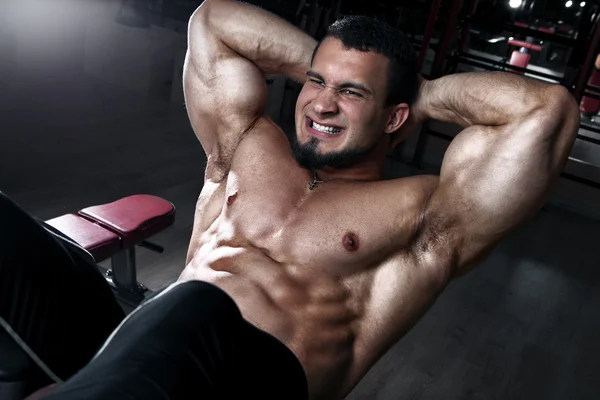 Bonito homem musculoso fazendo sit-ups . — Fotografia de Stock