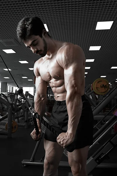 Homem musculoso trabalhando no ginásio fazendo exercícios no tríceps — Fotografia de Stock