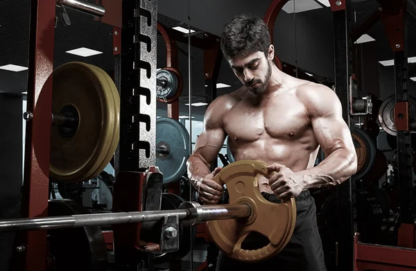 Bonito fisiculturista cara se preparar para fazer exercícios com barbell — Fotografia de Stock