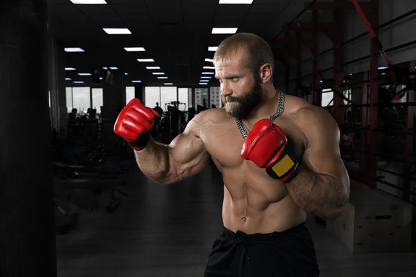 Erős, izmos ember az edzőteremben boksz. — Stock Fotó