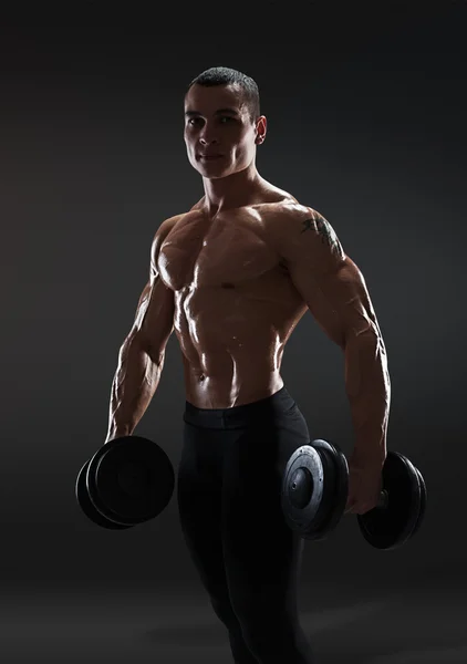 Handsome power athletic man bodybuilder doing exercises with dum — Stock Photo, Image