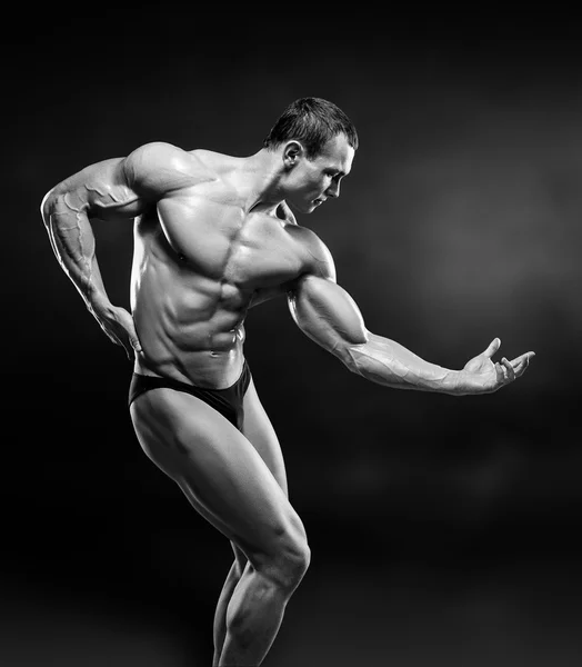 Handsome muscular bodybuilder posing over black background. — Stock Photo, Image