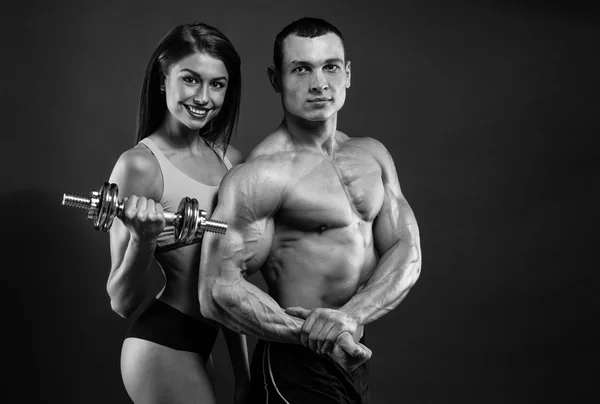 Athletic man and woman with a dumbells — Stock Photo, Image