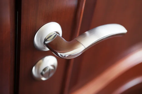 La manija de la puerta de metal en una puerta marrón — Foto de Stock