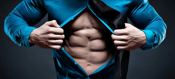 Young man displaying his abdominal muscles — Stock Photo, Image