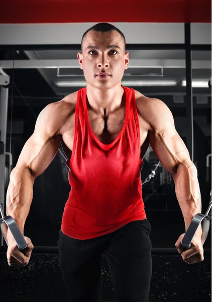 Bodybuilder, der beim Crossover Muskeln aufpumpt — Stockfoto