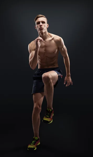 Hombre sano y fitness corriendo sobre fondo negro . —  Fotos de Stock