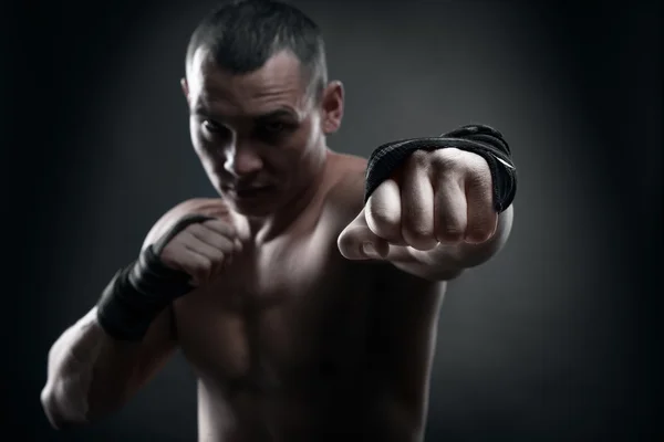 Fighter boxer and warriors fist on black background — Stock Photo, Image