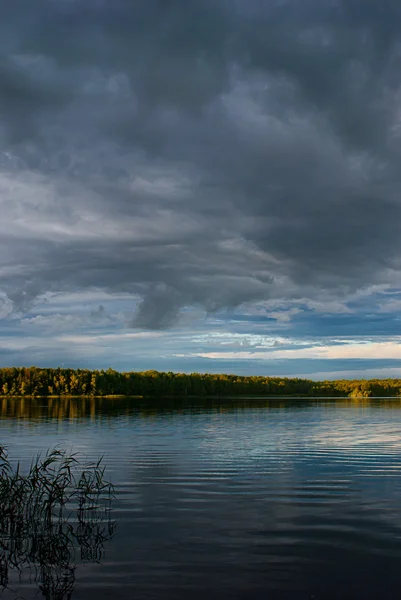 Puesta de sol sobre el lago del bosque con cielo dramático . — Foto de Stock
