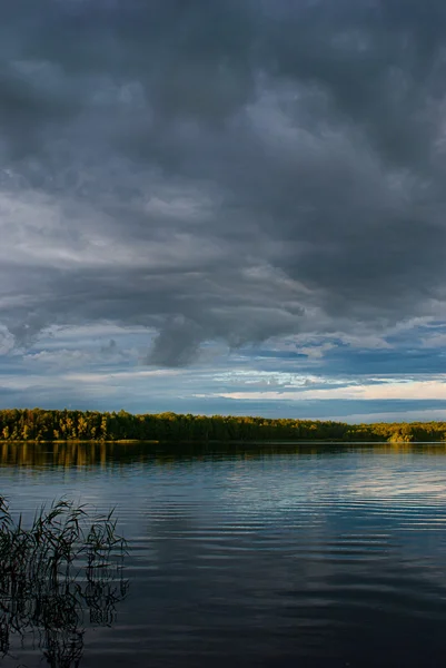 Solnedgång över sjön skog med dramatisk himmel. — Stockfoto