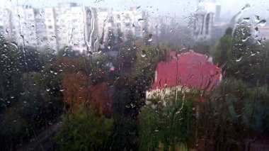 Edepsiz Eylül gününde pencere camına yağmur damlaları düşer.