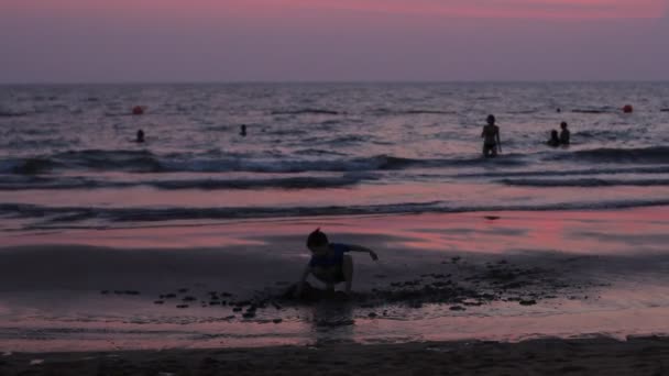 PATTAYA - 07 DE MARZO DE 2016: Puesta de sol en la playa con silueta de personas no identificadas caminando por la orilla. Tailandia . — Vídeo de stock