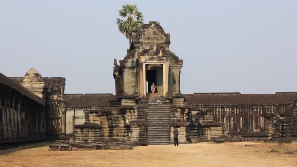 CAMBODIA, SIEM REAP PROVINCE, ANGKOR WAT, Março 09, 2016: Turistas não identificados assistir complexo templo. Angkor Wat é o maior monumento religioso do mundo na província de Siem Reap, Camboja — Vídeo de Stock