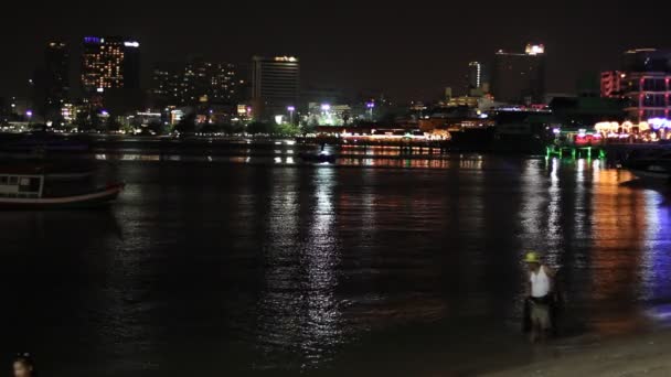 Pattaya - 10. März 2016: das Gebäude und die Wolkenkratzer in der Nacht. Unbekannte gehen am Ufer entlang. — Stockvideo