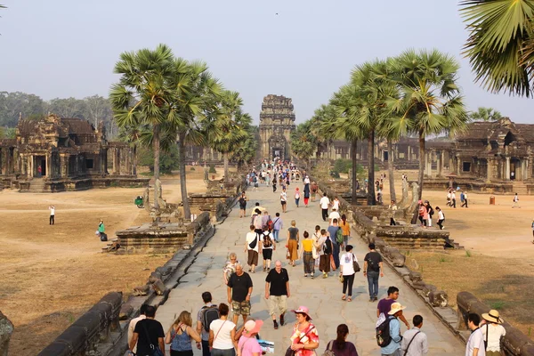 CAMBODIA, PROVINCIA SIEM, ANGKOR WAT, 09 DE MARZO DE 2016: Turistas no identificados observan complejo de templos. Angkor Wat es el monumento religioso más grande del mundo en la provincia de Siem Reap, Camboya — Foto de Stock