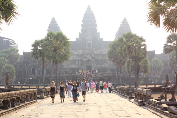 CAMBODIA, SIEM REAP PROVINCE, ANGKOR WAT, MARCH 09, 2016: Unidentified tourists watch temple complex. Angkor Wat is the largest religious monument in the world in Siem Reap province, Cambodia