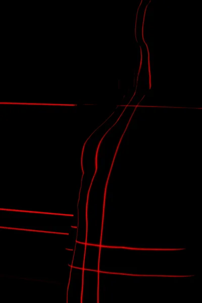 Абстрактный портрет. Силуэт обнаженной женщины, нарисованный лазерными красными линиями . — стоковое фото