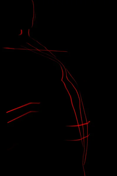 Abstracte portret. Silhouet van een naakte vrouw geschilderd door rode laserlijnen. — Stockfoto