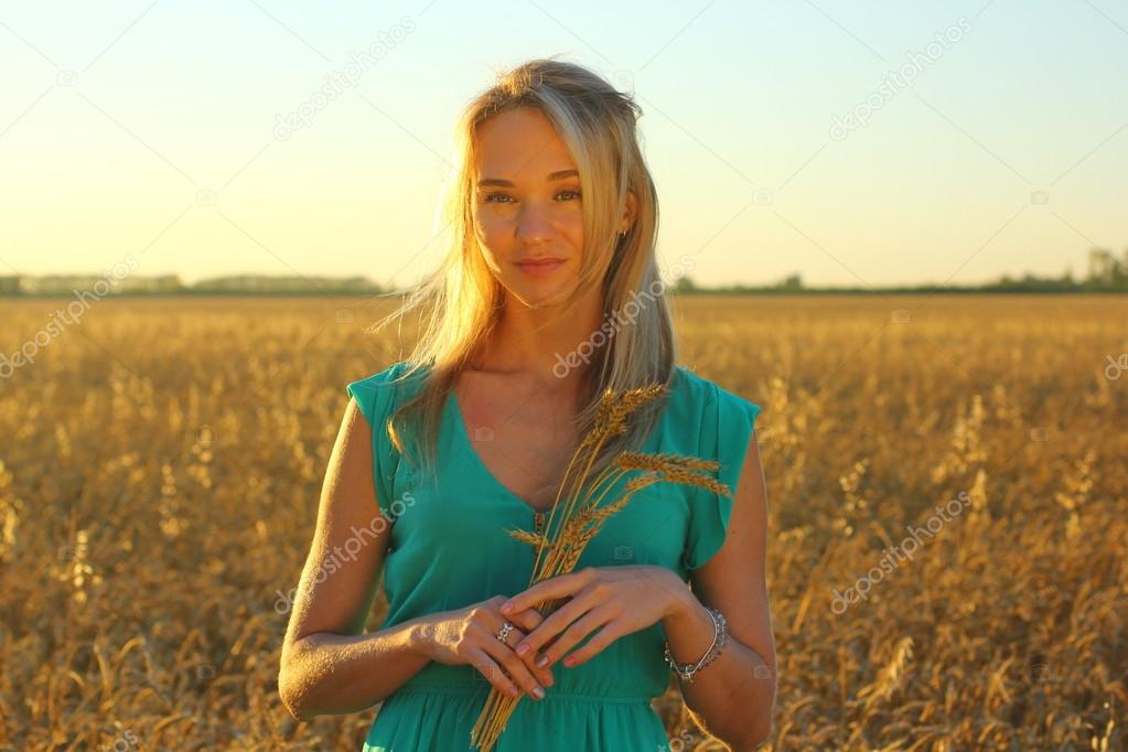 Close up of a Woman in a wheat field at dusk, the golden hour. Setting sun.