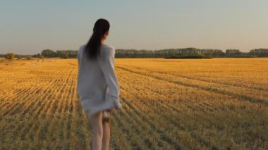 Genç kadının sarı alan sonbahar güneşte. Günbatımı ışığı ile altın saat.