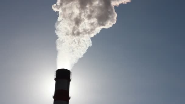 Silhueta de tubulação com uma fumaça no fundo do céu azul — Vídeo de Stock