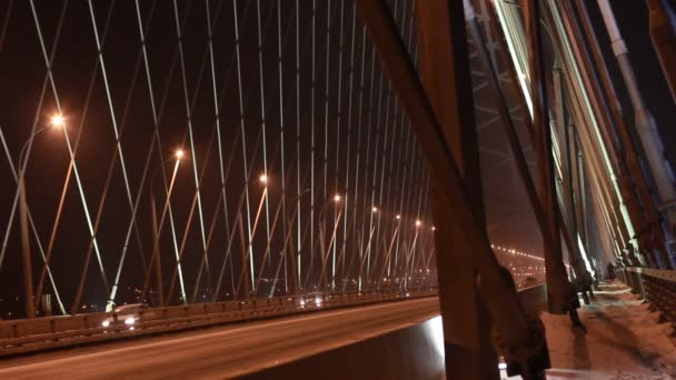 NOVOSIBIRSK, RUSIA - 14 DE MARZO DE 2015: Tráfico en la autopista moderna a través del nuevo puente Bugrinsky en la noche nevada, Novosibirsk, Rusia — Vídeos de Stock