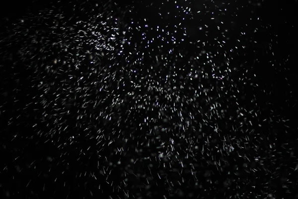 Textura abstracta de tormenta de nieve. Luces Bokeh sobre fondo negro, plano de copos de nieve voladores en el aire —  Fotos de Stock