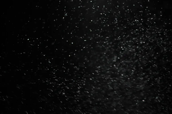 Texture abstraite de tempête de neige. Bokeh lumières sur fond noir, plan de flocons de neige volants dans l'air — Photo