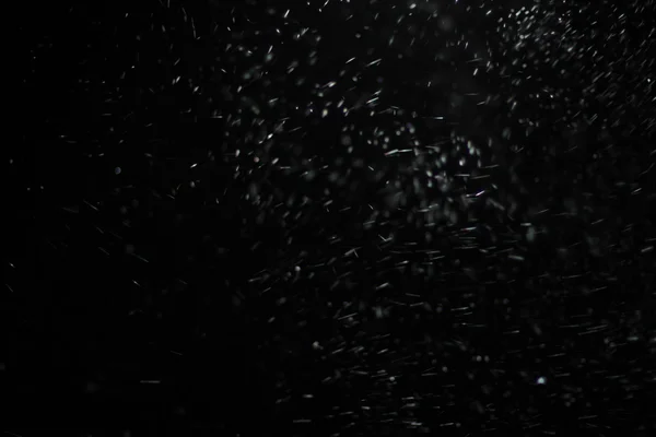 Textura abstracta de tormenta de nieve. Luces Bokeh sobre fondo negro, plano de copos de nieve voladores en el aire — Foto de Stock