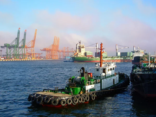 BUSAN - JULY 27 Towing work in the waters of the container terminal. Mooring containership at sunset light, July 27, 2006 in Busan Korea. — Stock Photo, Image