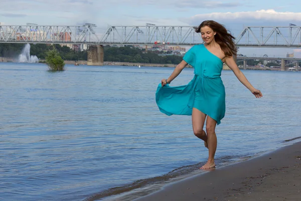 Attraktive Mädchen haben Spaß am Stadtstrand im Wasser. Frauenporträt mit blauem Kleid. — Stockfoto