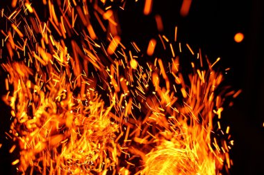 Yangının neden olduğu fırtına doku. Bokeh ışık siyah arka plan üzerine, havada uçan ateş çekim kıvılcım