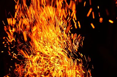 Yangının neden olduğu fırtına doku. Bokeh ışık siyah arka plan üzerine, havada uçan ateş çekim kıvılcım